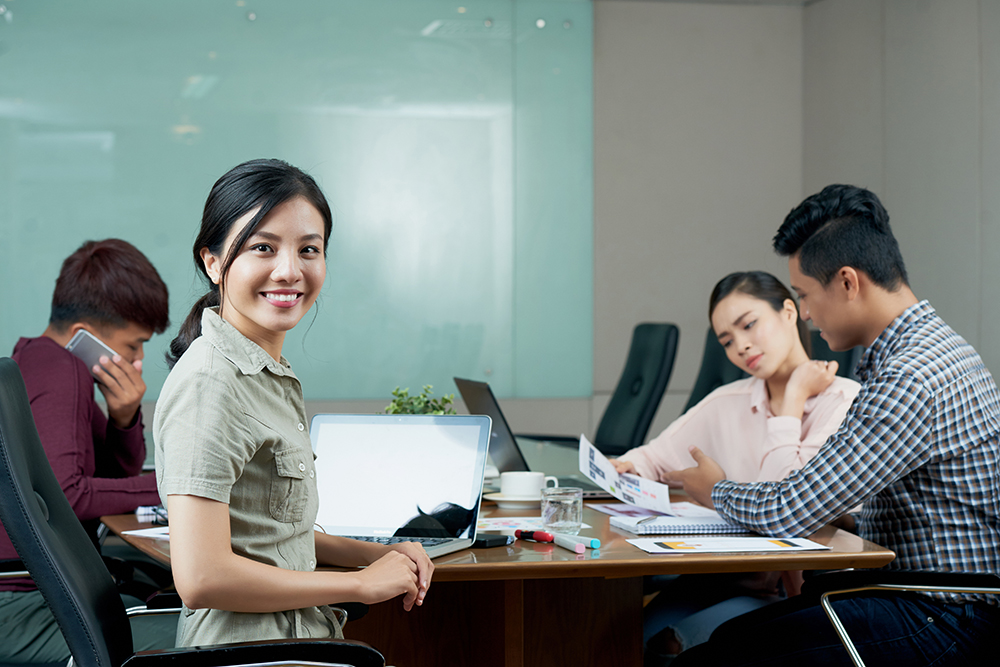 Beautiful Vietnamese business lady having meeting with colleagues